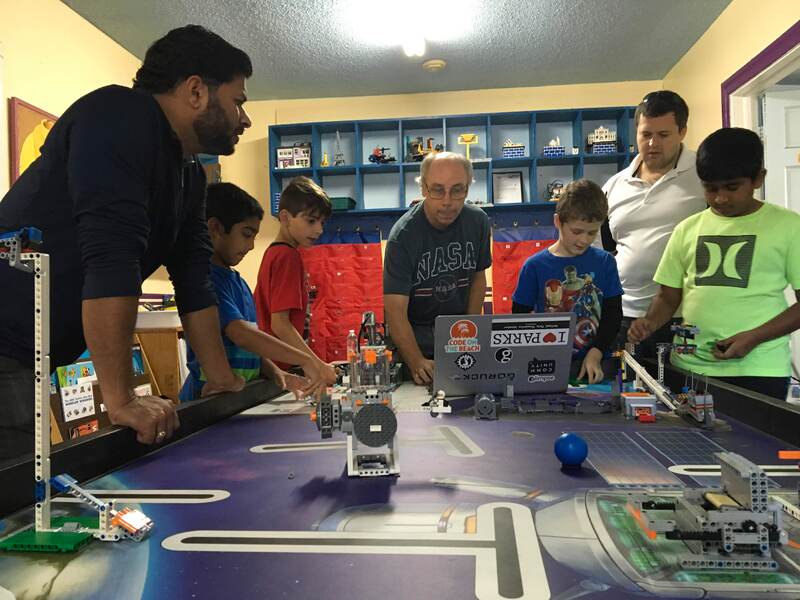 Pictures of dads working with their children on robotics.